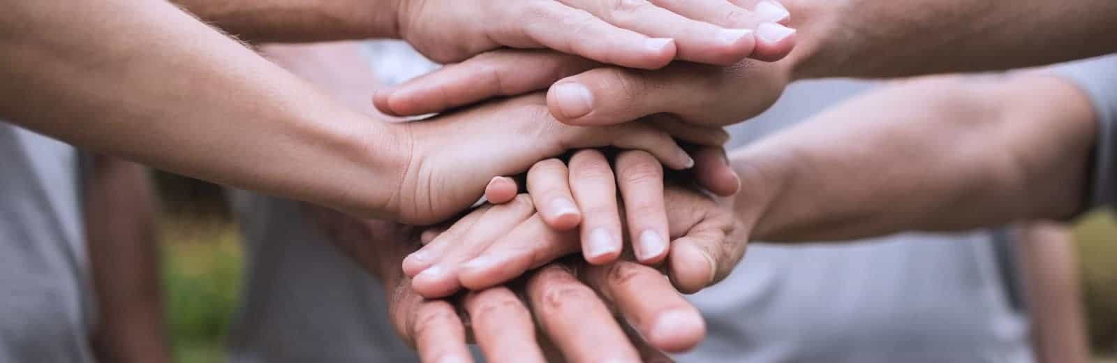 People with hands stacked atop one another
