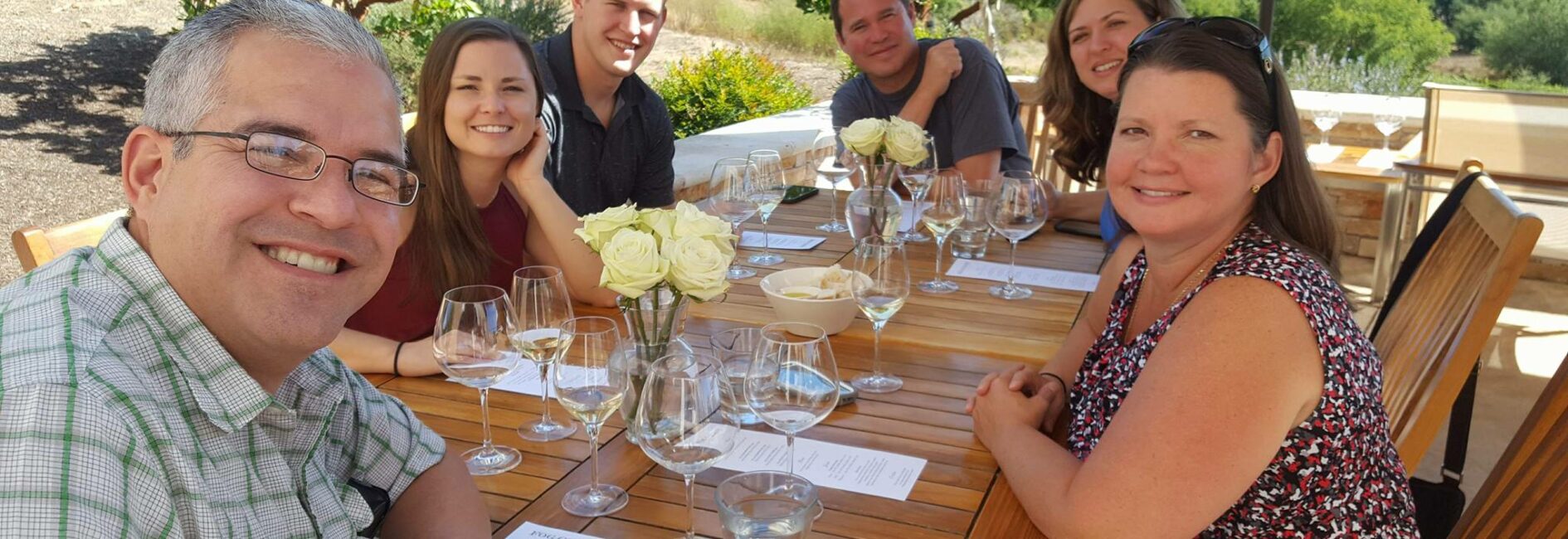 Happy people wine tasting around a table